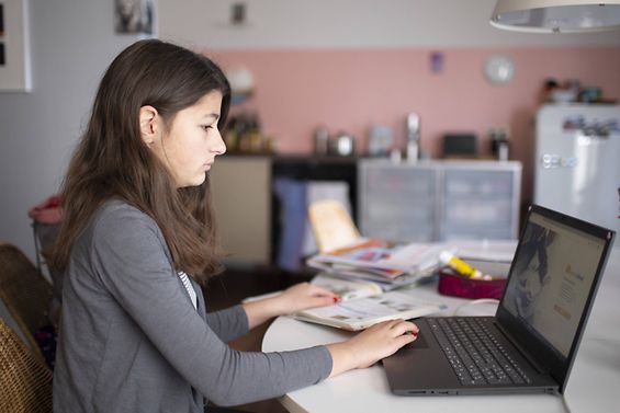 Eine Schülerin nimmt über einen Computer am Unterricht teil.