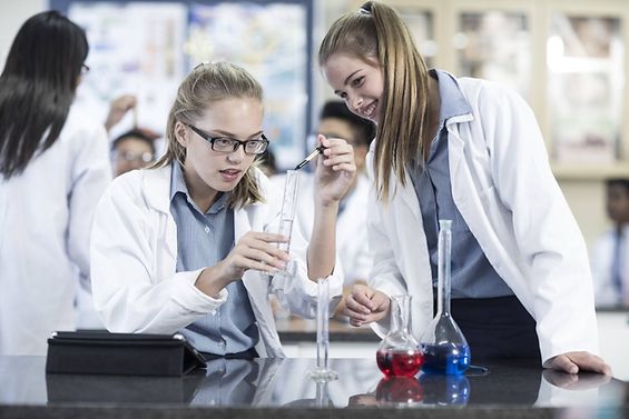 Schülerinnen führen ein Chemiexperiment durch.