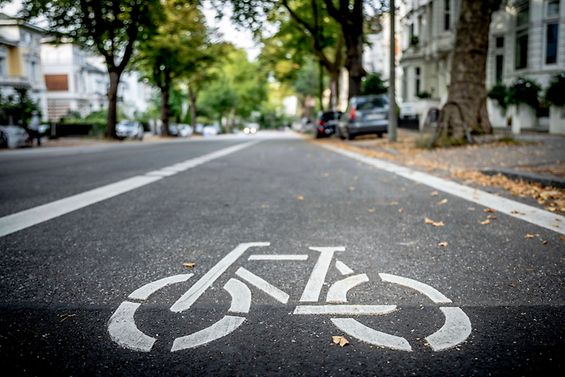 Ein Piktogramm eines Fahrrads ist auf eine Straße gedruckt worden.